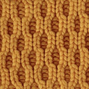 Close-up of a honey-colored cashmere knit featuring a deep ribbed honeycomb pattern.